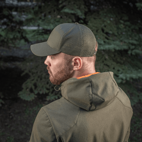 Mies metsässä käyttää M-Tac Mesh Flex Ripstop Baseball Capia; näkyvillä säädettävä Velcro-tarranauha ja mesh-paneelit ilmanvaihtoa varten.