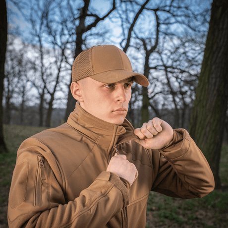 Mies pitää M-Tac Mesh Flex Ripstop Baseball Cap en metsässä; käytännöllinen ja kestävä, tarjoaa mukavuutta ja ilmanvaihtoa ulkoiluun.