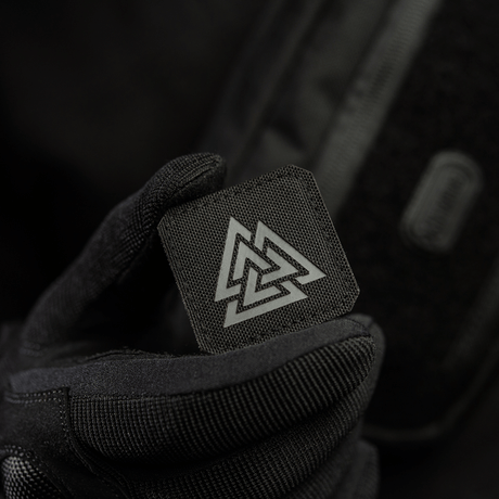 M-Tac Patch Valknut Laser Cut Odin -symboli Völknot-kuviolla mustalla taustalla, pidetty en kädellä, jossa musta hansikas