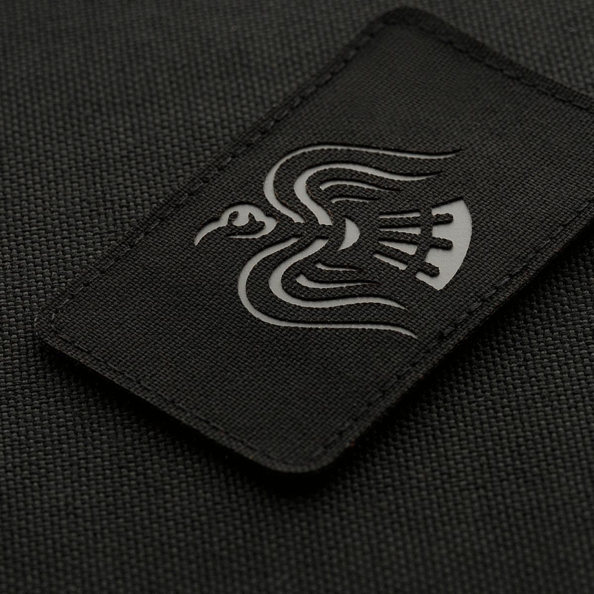 M-Tac Patch Ravneflag Laser Cut – musta korppi, symboloi sodanhimoa, mustalla taustalla; Cordura 500D, kiinnitys Velcro.