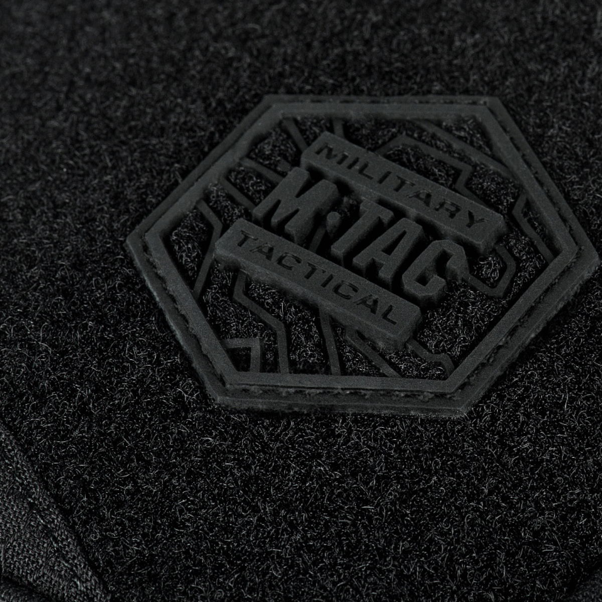 Lähikuva M-Tac Sling -pistoolilaukku Elite Hex Velcro, Velcro-logo mustassa Cordura-kankaassa.