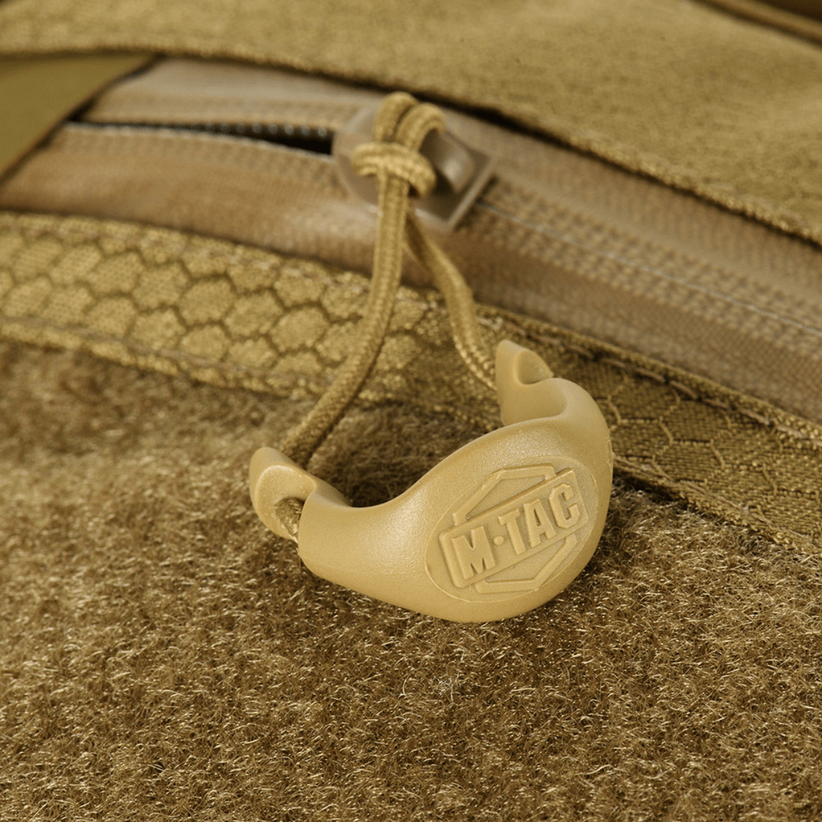 Yksityiskohta M-Tac Sling -pistoolilaukku Elite Hex Velcro, vetoketju ja kantokahva logolla, valmistettu kestävästä Cordura-materiaalista.
