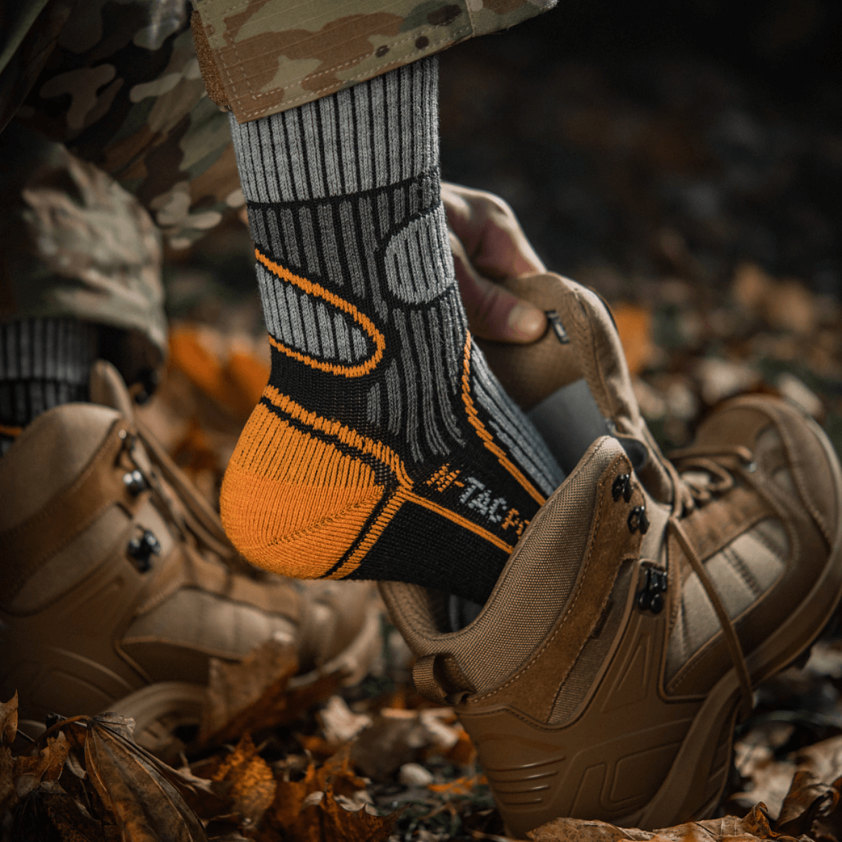 Henkilö pukeutuneena M-Tac Sukat Polar Merino 40% maastopuvussa ja vaellussaappaissa.