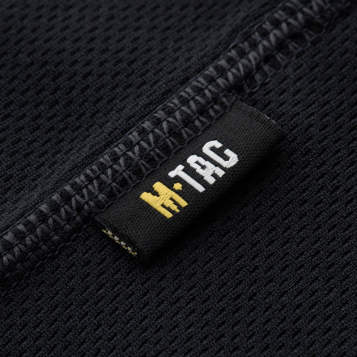 M-Tac Sweat-Wicking T-Shirt Athletic kosteutta siirtävästä kankaasta ja anatomisella istuvuudella, lähikuva paidan saumoista ja logotarrasta.