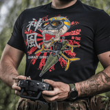 Mies M-Tac T-Shirt Kamikaze Spirit -paidassa FPV-kuviolla pitelee drone-ohjainta; musta T-Shirt, tyylitelty kalloprintti.