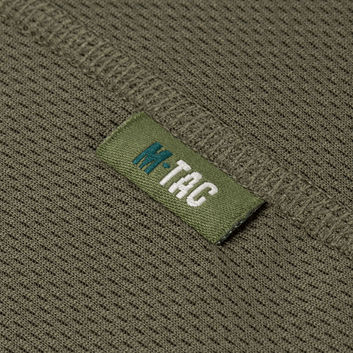 Yksityiskohta M-Tac T-Shirt Raglan Sweat-Wicking Tactical Summerista, oliivinvihreä polyesteri, näkyvä logo.