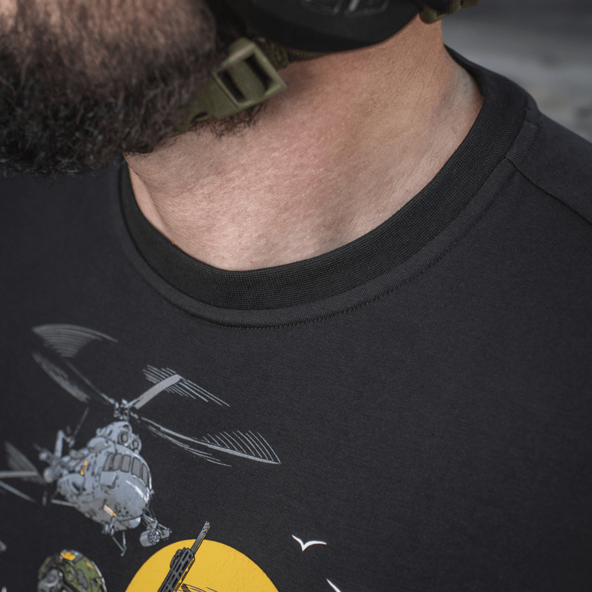 Mies pukeutuneena M-Tac T-Shirt Surf Clubiin, design innoittanut ukrainalaiset erikoisoperaatiot ja surffikohtaukset; lähikuva painatuksesta.