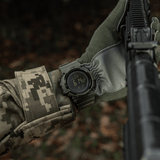 M-Tac Tactical Ur med Kompas 2233 sotilaan ranteessa metsässä, toimintoja ulko- ja taktiseen käyttöön, kestävä muotoilu ja kompassi.