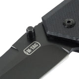 M-Tac Outdoor & Militær taittoveitsi - Type 5, lähikuva G10-komposiittikahvasta, näkyvä ruostumaton terä ja logo.
