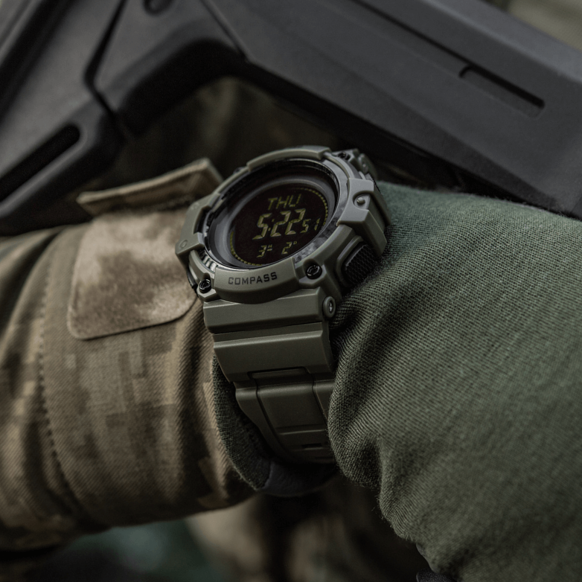 M-Tac Tactical Ur med Kompas 2233 sotilasvarusteisessa käsivarressa, tutkimus- ja ulkoiluseikkailuihin, kestävä kello kompassilla ja LED-näytöllä.