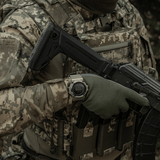 Henkilö maastopuvussa kantaa M-Tac Tactical Ur Kompas 2233 sotilasympäristössä en