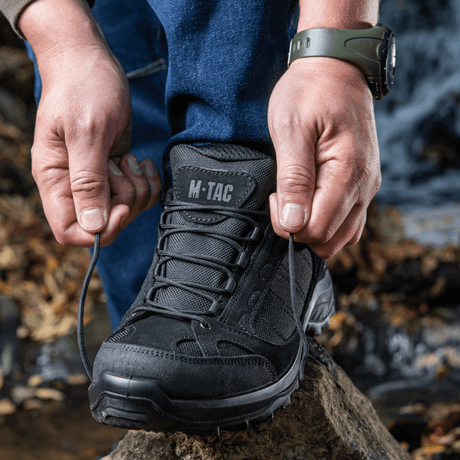 Henkilö solmii Tactical Sneakers Demi-Season – Kevyt ja mukava metsäpolulla, ihanteellinen trekkingiin ja polkujuoksuun, kestävä pohja.
