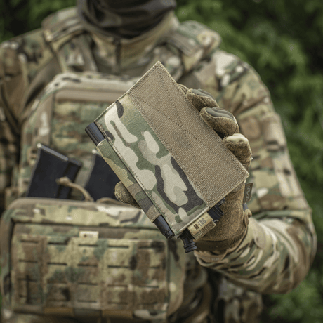 M‑Tac Tourniquet Pouch Elastic Gen.5 sotilaan pitämänä maastokuvioisessa univormussa, sopiva CAT-tourniquetille taktisessa varustuksessa.