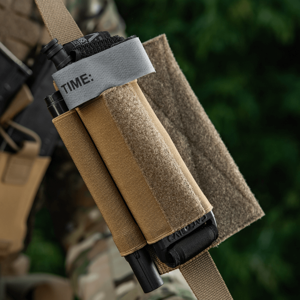 M‑Tac Tourniquet Pouch Elastic Gen.5 Cordura 500D:ssä taktisessa varustuksessa, näyttää nopean pääsyn ja tourniquetin varman kiinnityksen.