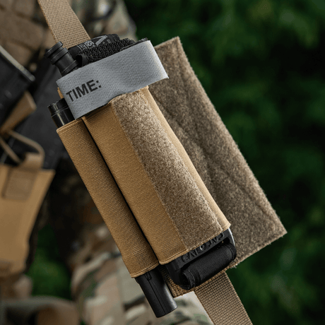 M‑Tac Tourniquet Pouch Elastic Gen.5 Cordura 500D:ssä taktisessa varustuksessa, näyttää nopean pääsyn ja tourniquetin varman kiinnityksen.