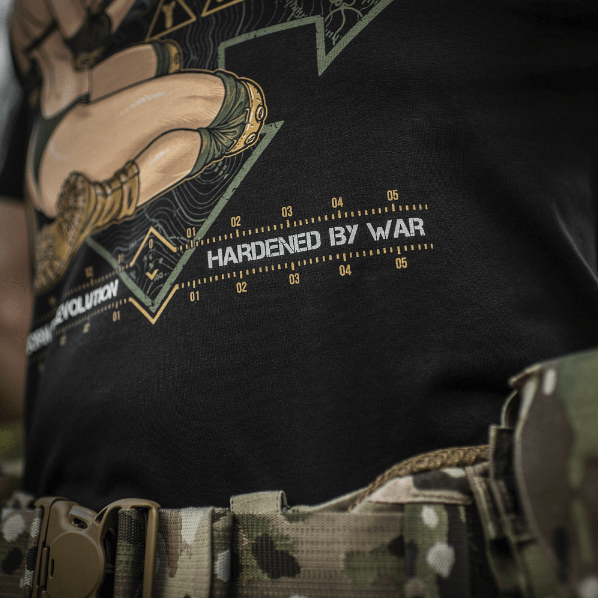 M-Tac T-Shirt Delivery Service, pin-up-kulttuurista innoituksensa saanut, näyttää dronea ohjaavan tytön ja tekstin "Hardened by War".