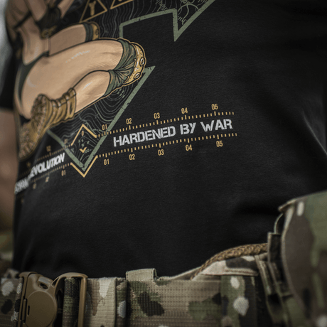 M-Tac T-Shirt Delivery Service, pin-up-kulttuurista innoituksensa saanut, näyttää dronea ohjaavan tytön ja tekstin "Hardened by War".
