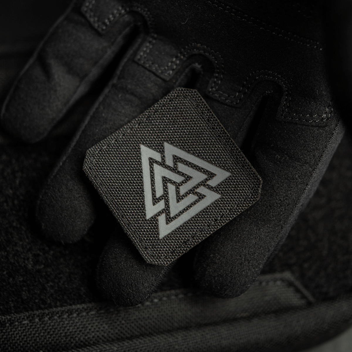 M-Tac Patch Valknut Laser Cut Odin -symboli mustana, pidetty en mustassa hansikkaassa, näyttää Valknutin yksityiskohdat