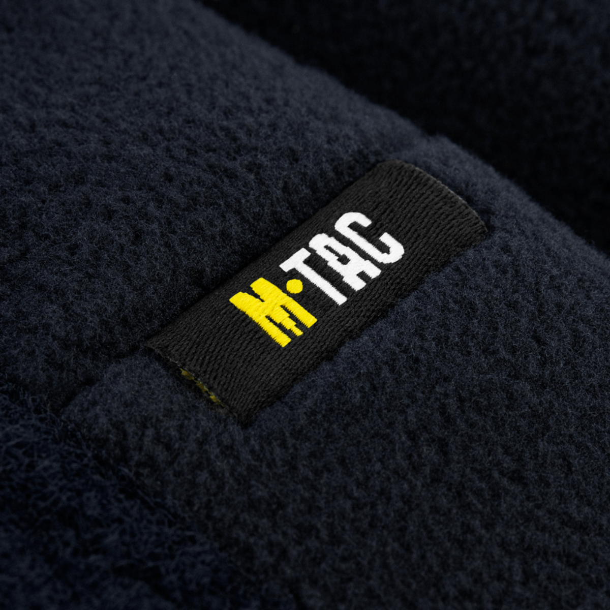 M-Tac Watch Cap Elite Fleece Beanie Hat Velcro, tummansininen fleece lähikuvassa, merkki näkyvissä. Ihanteellinen kylmään säähän ja taktiseen käyttöön.