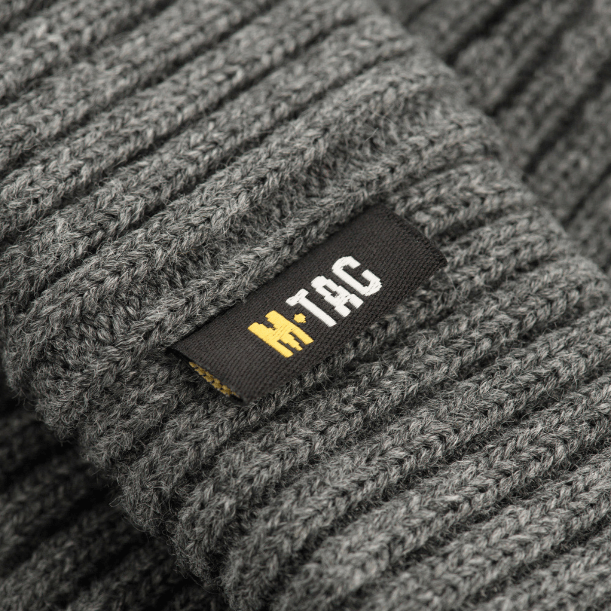 M-Tac Watch Cap 100% Akryl harmaa, neulospipo viileään säähän, matala profiili ja kaksoiskäänne lisälämmöksi, lähikuva tekstuurista.
