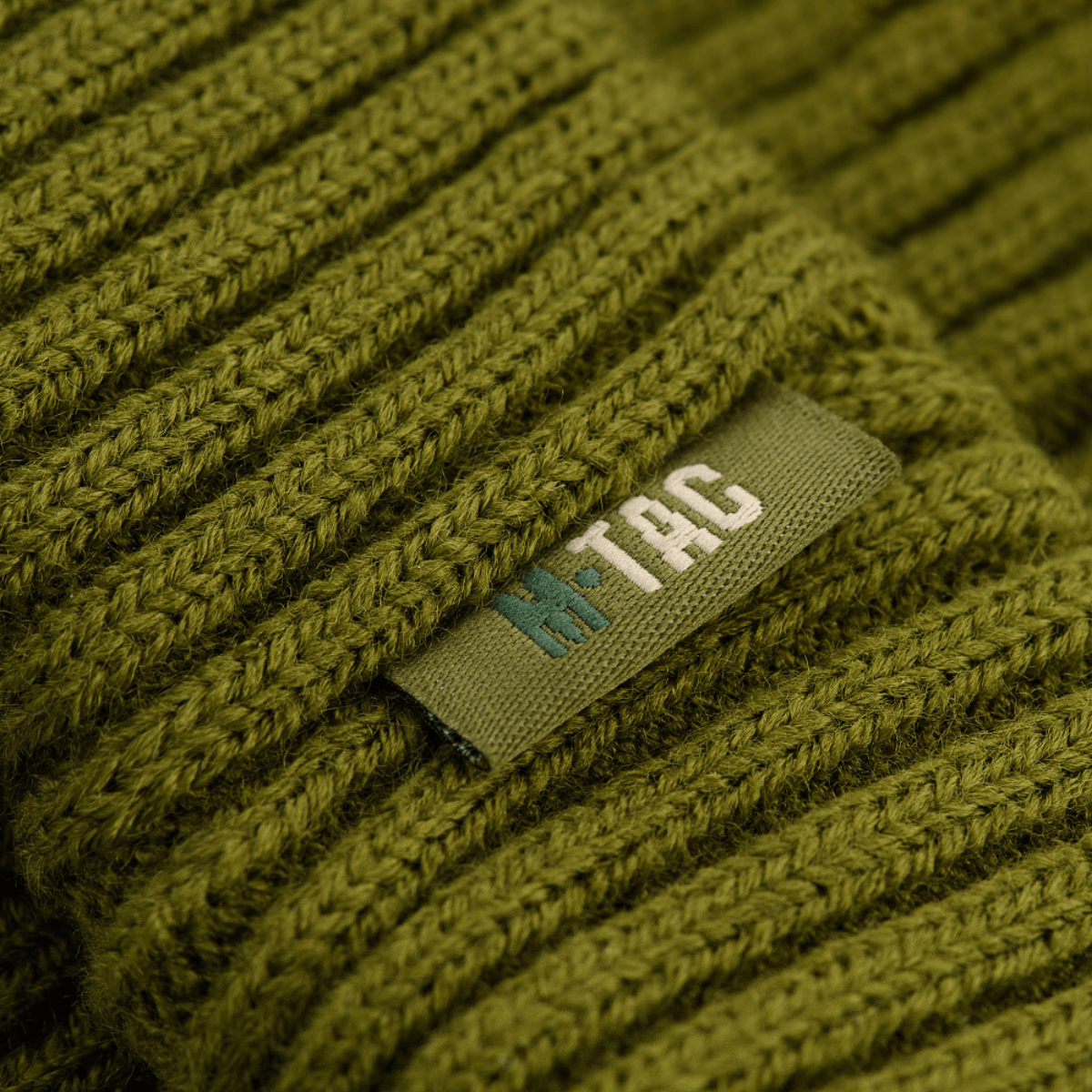 M-Tac Watch Cap 100% Akryl oliivinvihreä teollisella neuloksella, esittelee merkin kestävänä, lämpimänä pipona viileään säähän.