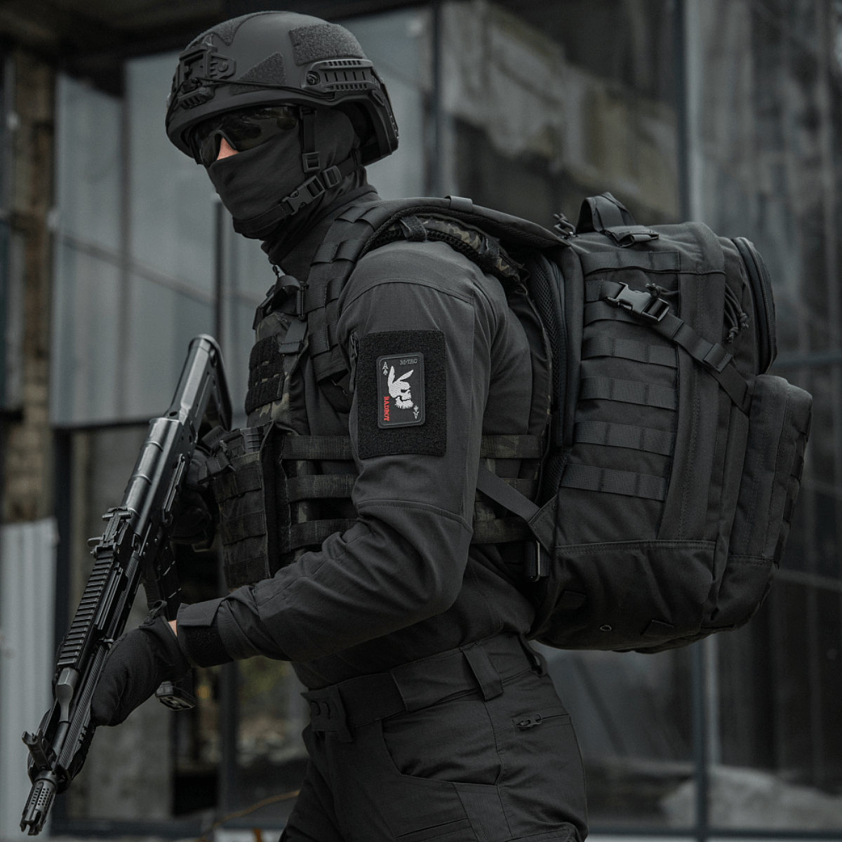 Taktinen operaattori käyttää "M-Tac Patch Bad Boy (Broderi)" -merkkiä, kanin kallo ace of spades -kortissa, ase kädessä urbaanissa ympäristössä.