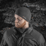 Mies pukeutuneena M-Tac Fleece Watch Cap Light Polartec talvimaisemassa.