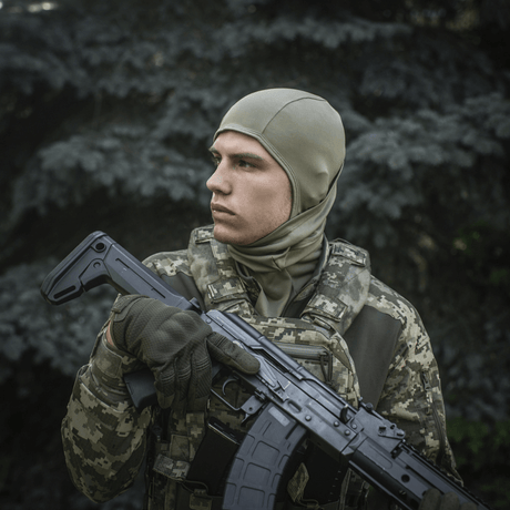 Sotilas käyttää M-Tac Sweater-Ninja-Balaclava Premiumia viidakkovaatetuksessa pitäen asetta, sopii kosteudenhallintaan ja mukavuuteen
