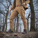 M-tac taktiset housut Conquistador Gen. I Flex ulkoaktiviteetteihin, kestävä polycotton Rip-stop Flex metsäympäristössä.