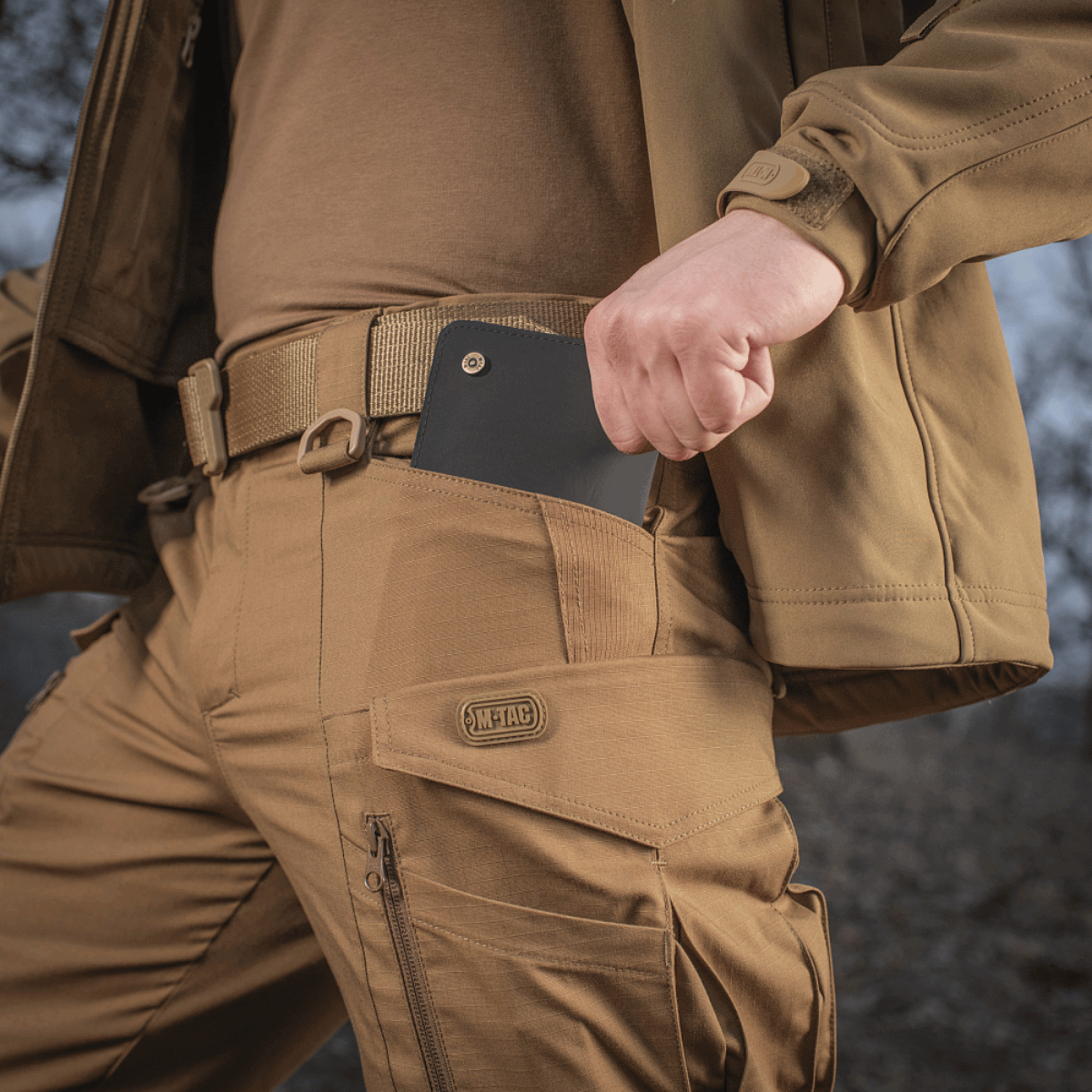 M-tac taktiset housut Conquistador Gen. I Flex – kulutusta kestävä polycotton rip-stop ulkoaktiviteetteihin, esitetty käytössä.