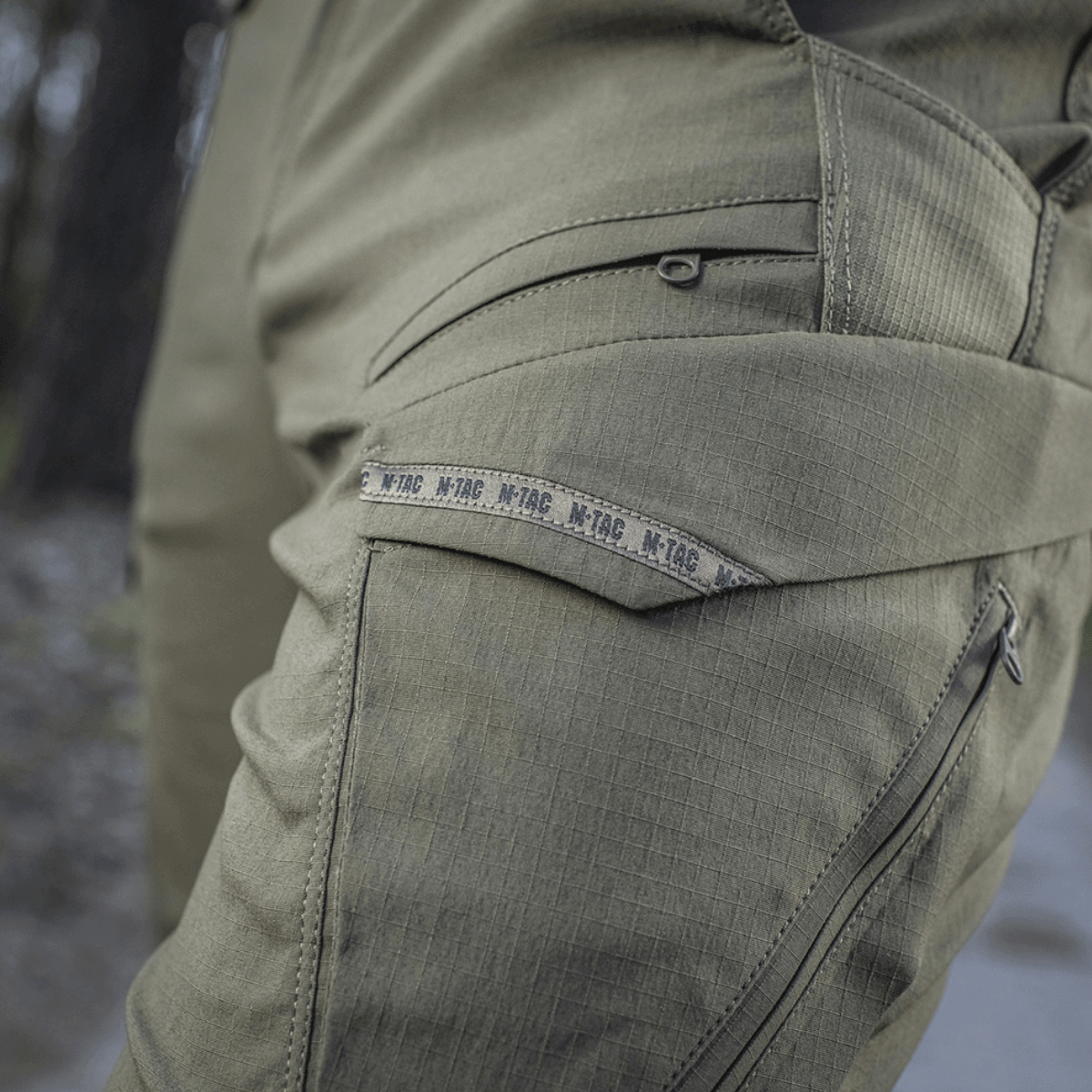 Yksityiskohtia M-Tac Aggressor Summer Flex -housuista, kevyt Rip-stop-nylon, sopii taktiseen käyttöön ja mukavuuteen lämpimässä säässä.