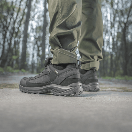 Henkilö pukeutuneena M-Tac Aggressor Summer Flex -housuihin metsässä, näyttää housujen mukavuuden ja kestävyyden luonnollisessa ulkoilumaisemassa.