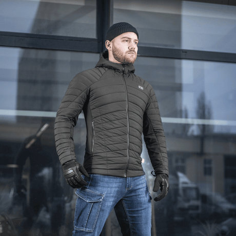 Mies pukeutuneena M-Tac Jarl -takkiin, monipuolinen välikausitakki G-Loft-eristyksellä suojaksi kylmää ja tuulta vastaan.