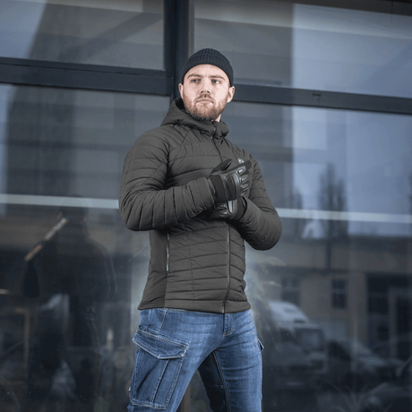 M-Tac Jarl -miesten musta takki, tuulenpitävä ja lämmin, malli seisoo ulkona, täydellinen kylmään säähän, takin yksityiskohdat näkyvissä.