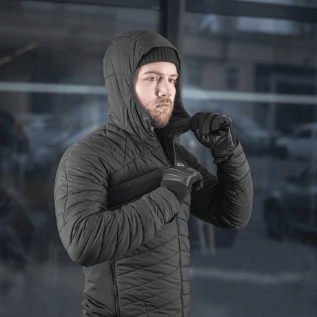 Mies pukeutuneena mustaan M-Tac Jarl -takkiin, sopii suojaksi kylmää ja tuulta vastaan, valmistettu Toray mechanical stretch -nylonista ja G-Loft-täytteellä.