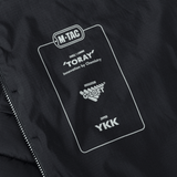 Yksityiskohta M-Tac Jarl -takista Toray-, G-Loft- ja YKK-merkinnöillä.