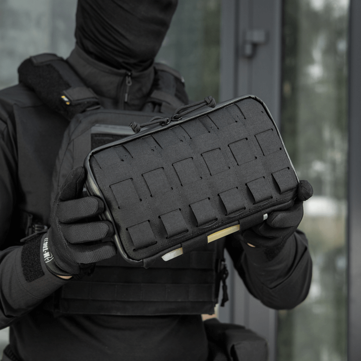 Musta M-Tac Admin Pouch Large Elite Gen.II käytössä Cordura-materiaalilla; sopii tabletille ja pienten tavaroiden säilytykseen.