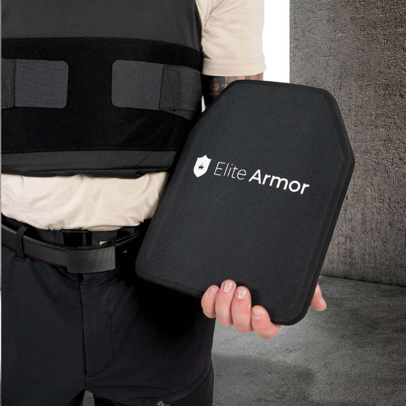 Person i skudsikker vest holder Elite Armor plade til beskyttelse.