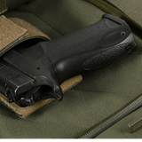 Kuva M-Tac Buckler Taske Elite Hexistä, piilotettu asekotelo ja MOLLE-järjestelmä harmaalla taustalla.